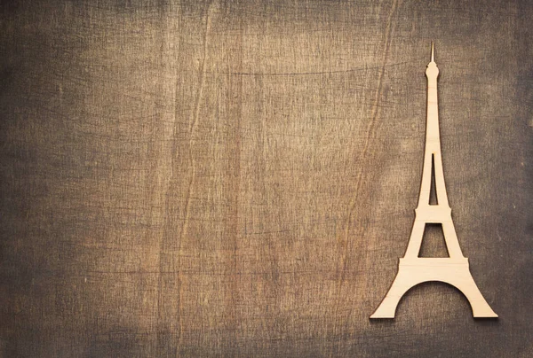 wooden eiffel tower toy at plywood background surface