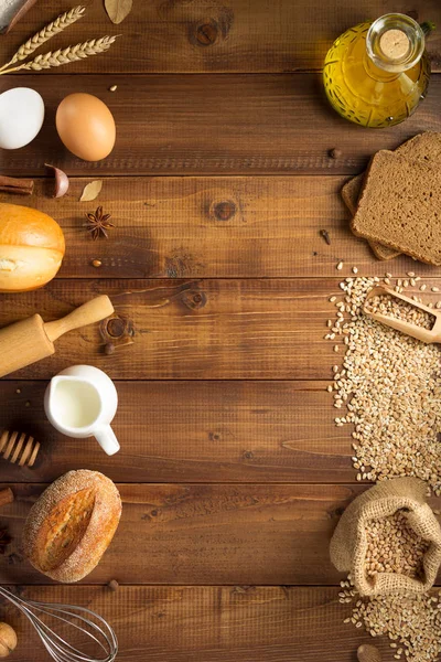 Tarwe granen en bakkerijgrondstoffen op hout — Stockfoto