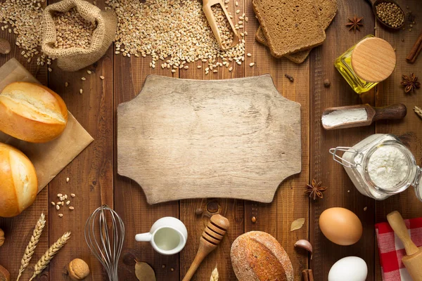 Tarwe granen en bakkerijgrondstoffen op hout — Stockfoto