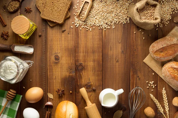 Tarwe granen en bakkerijgrondstoffen op hout — Stockfoto