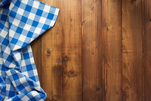 Checked cloth napkin at wooden table — Stock Photo, Image
