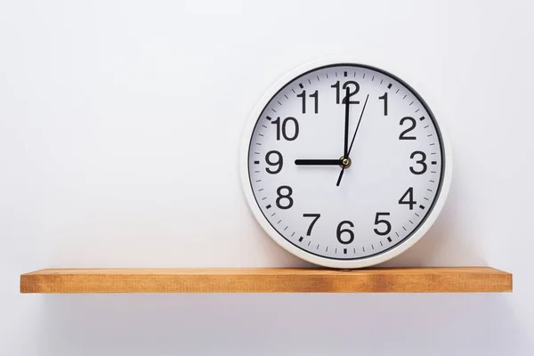 Wall clock at shelf on white background — Stock Photo, Image