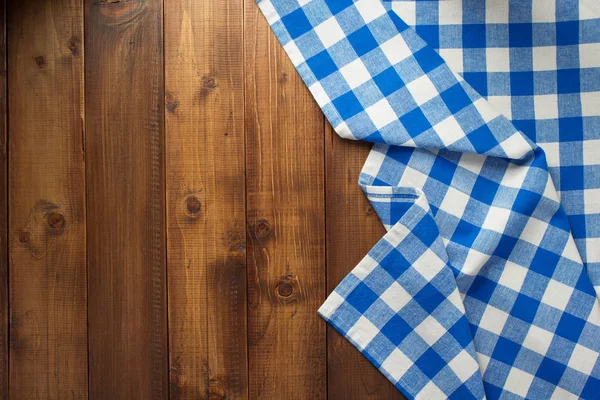 Checked cloth napkin at wooden table — Stock Photo, Image