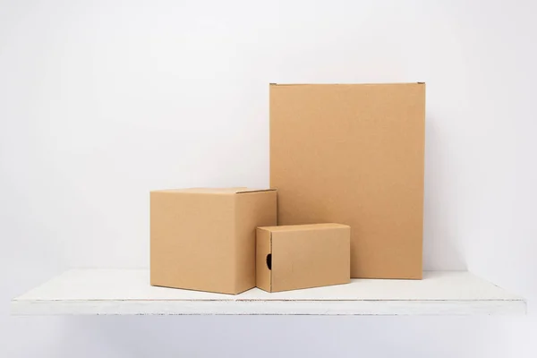 Kartonové krabice na dřevěné police — Stock fotografie