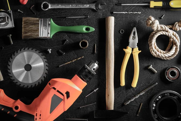 Borrmaskin och verktyg på svart — Stockfoto