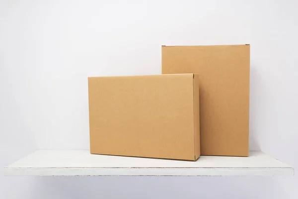 Cardboard box on wooden shelf — Stock Photo, Image