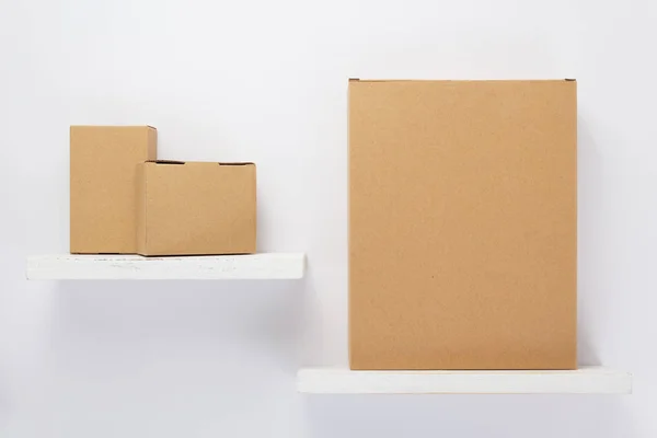 Caixa de papelão na prateleira de madeira — Fotografia de Stock