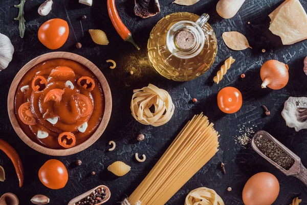 Salsa de tomate en tazón y pasta en negro —  Fotos de Stock