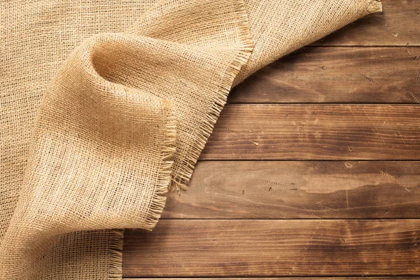 Burlap hessian sacking no fundo de madeira — Fotografia de Stock