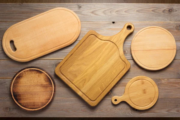 Cutting board at wooden plank table — Stock Photo, Image