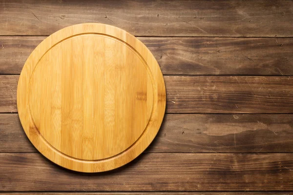 Tabla de cortar pizza en el fondo tablón de madera — Foto de Stock