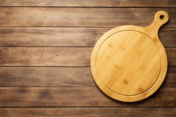 Placa de corte de pizza em prancha de madeira plano de fundo — Fotografia de Stock