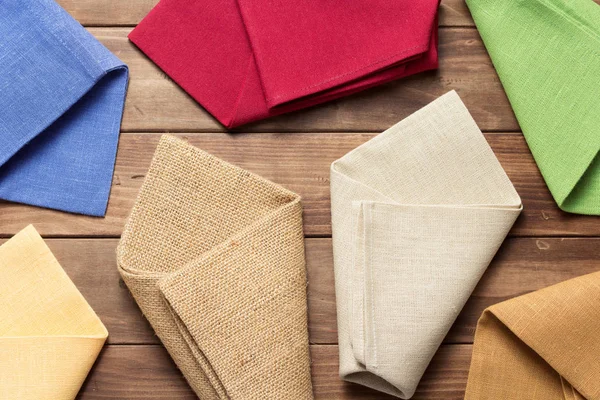 素朴な木製の背景に布ナプキン、トップビュー — ストック写真