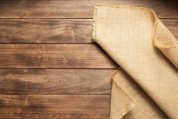 Burlap hessian sacking na mesa de fundo de madeira — Fotografia de Stock