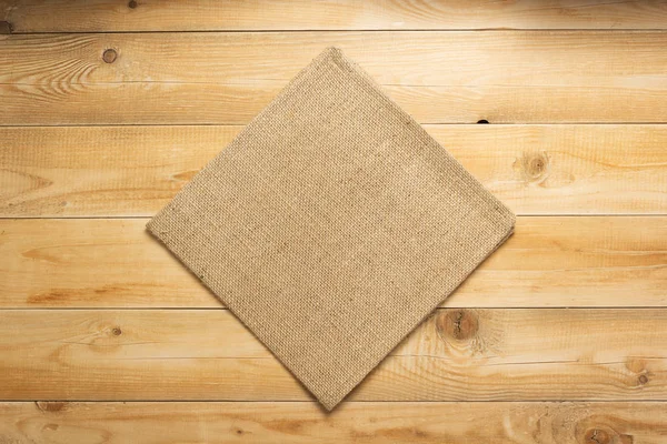 Pano de saque hessian burlap no fundo de madeira — Fotografia de Stock