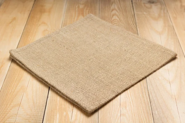 木製のテーブルの上にヘッシアンのしゃぶり布をバーラップ — ストック写真