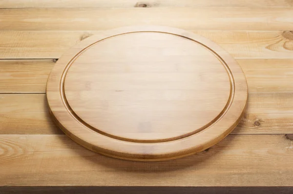 Deska na pizzu na rustikálním dřevěném stole — Stock fotografie