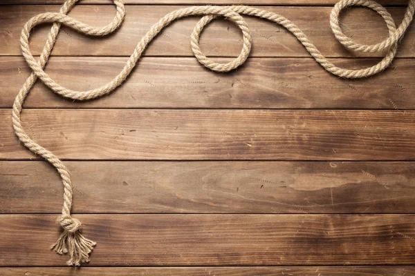 Ship rope at wooden board background — Stock Photo, Image