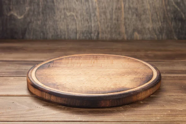 Pizza cutting board at rustic wooden table — Stock Photo, Image