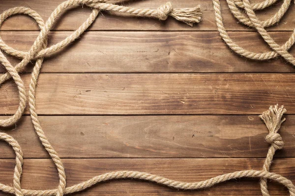 Ship rope at wooden board background — Stock Photo, Image