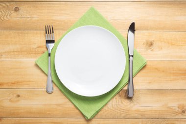 ahşap arka planda plaka, bıçak ve çatal