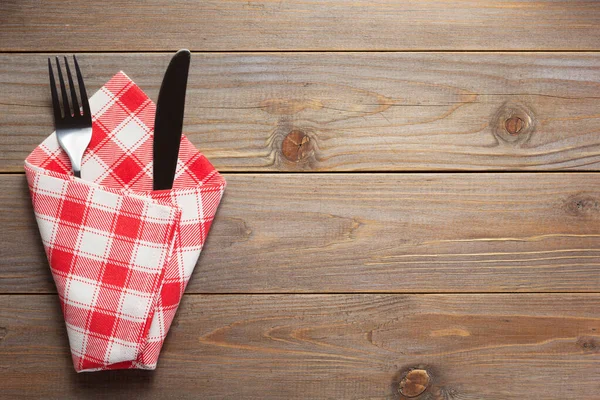 Cuchillo y tenedor en servilleta sobre fondo rústico de madera —  Fotos de Stock