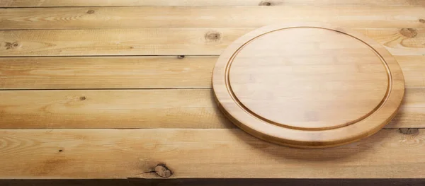 Доска для разрезания пиццы за деревенским деревянным столом — стоковое фото