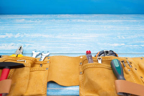 Werkzeuge und Instrumente im Gürtel auf Holztisch — Stockfoto
