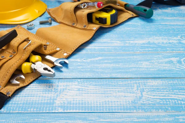 Tools and instruments in belt on wooden table — Stock Photo, Image