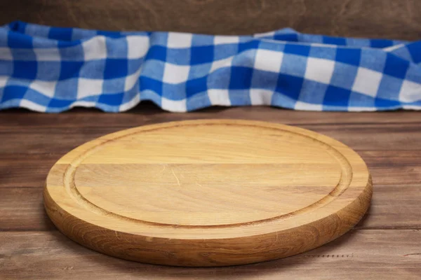 Deska do krojenia pizzy i obrus do serwetek przy drewnianym stole — Zdjęcie stockowe