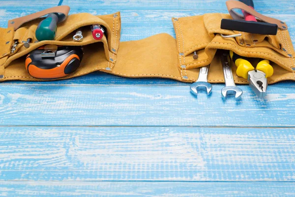 Werkzeuge und Instrumente im Gürtel auf Holztisch — Stockfoto