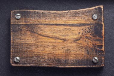 Tahta kaplama arkaplan dokusu yüzeyinde vidalarla eski ahşap isim plakası