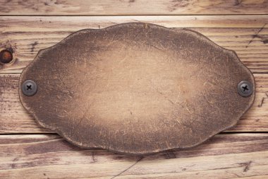 Tahta arkaplan doku yüzeyinde vidalı isim levhası ya da duvar levhası