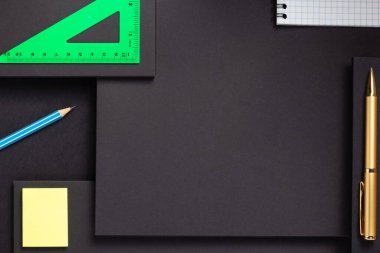 Okul aksesuarları ve ofis malzemeleri soyut siyah kağıt arka planda