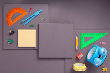Soyut gri kağıt arka planda okul aksesuarları ve ofis malzemeleri