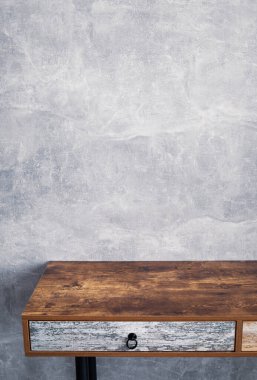 Gri duvar arkaplan dokusu yüzeyinin yanındaki ahşap masa