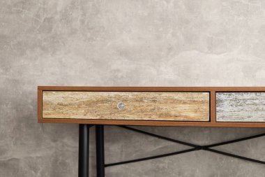 Gri duvar arkaplan dokusu yüzeyinin yanındaki ahşap masa