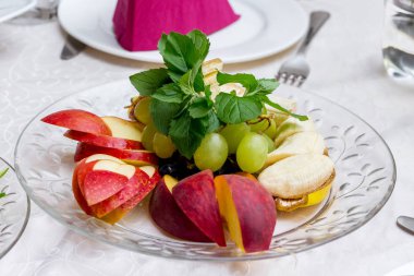 Elma, muz, üzüm şenlikli bir tabloda bir restoranda bir tatlı