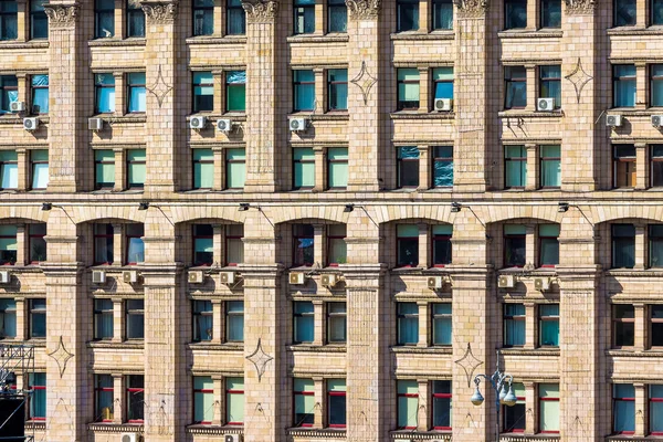 A wall of a multistory building with windows that form a pattern