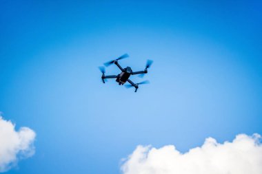 Bir fotoğraf çekerken mavi bir gökyüzü arka plan üzerinde quadcopter