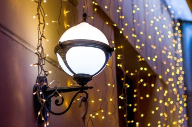 Lambalar ve Noel ve yeni yıl tatilleri sırasında evin duvarına çelenk