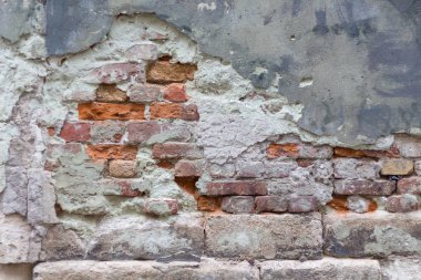 Hasarlı alçı duvar eski bir bina. Hasarlı sıva ile tuğla görebilirsiniz