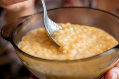 Kadın kabak püresi yiyor. Bir tabak yulaf lapası yakın çekim
