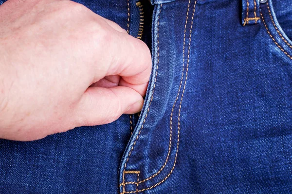 A man zips his jeans.  Man clothe oneself jeans