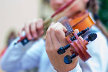 Müzikal oyunu sahnelerken kızın ellerinde keman
