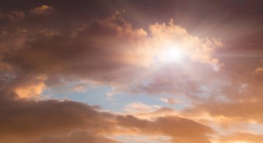 Gün batımında güneş ışınları bulutları delip geçer. Bulutlu ve güneşli gökyüzü