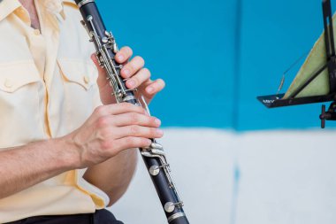 Adam konser sırasında klarnet çalar.