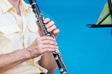 Adam konser sırasında klarnet çalar.