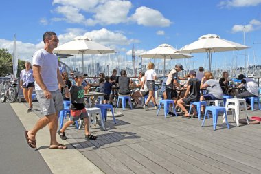 Auckland - 25 Mart 2018:Visitors Westhaven Marina içinde Auckland skyline karşı yemek. 2012 yılında İngiltere'de kağıt telgraf okuyucuları Yeni Zelanda tatile gitmek için dünyanın en iyi ülkesi seçti.