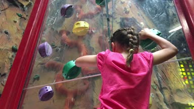 Genç kız (7 yaş) üzerinde tırmanma duvarı tırmanışı.